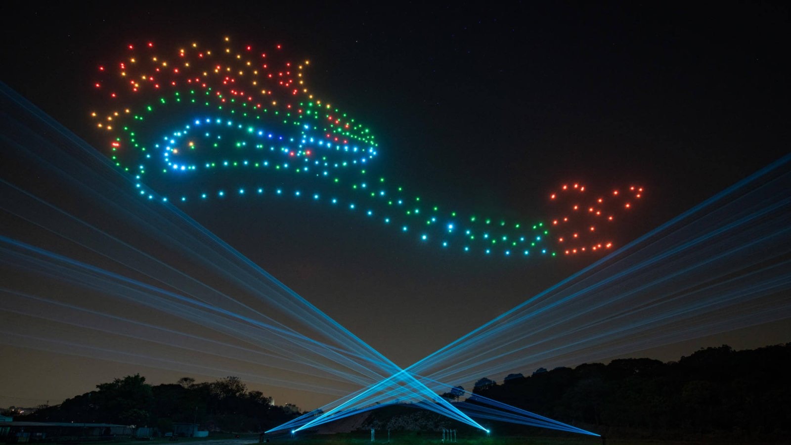 Show de drones colorido no céu com feixes de mega lasers cruzando a partir do solo